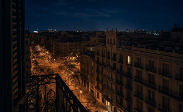 Vista nocturna de l'Eixample de Barcelona des d'una finestra amb un sol llum encès: la solitud de la inquietud nocturna