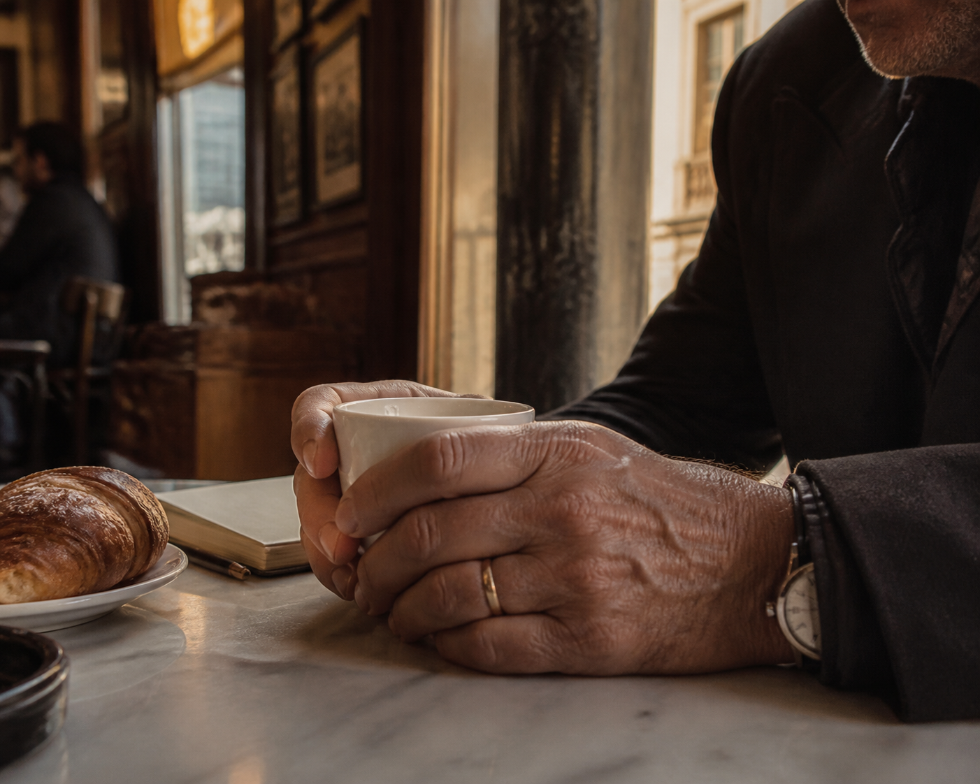 Pensaments intrusius: mans aferrant una tassa de cafè en un bar de Barcelona al matí, rumiant el mateix pensament